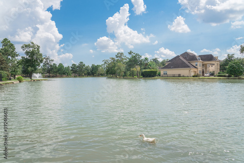 Neighborhood park with waterfront house and active water fountain in suburbs Houston, Texas, USA photo