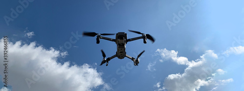 Ultra wide panoramic photo of latest technology RC camera drone or UAV (unmanned aerial vehicle) hovering on deep blue cloudy sky