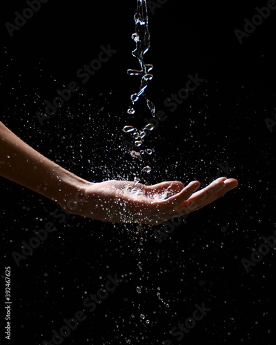 water drop on a man s hand with black background