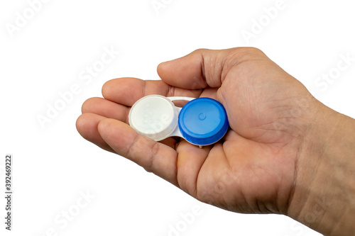 Contact lens case, blue and white Rests on the right hand on a white background