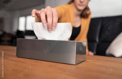 Fototapeta Blurred young woman grabbing a paper handkerchief from a stainless steel dispens