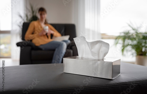 Quadro su tela Focus of a stainless steal dispenser with paper handkerchiefs and a young woman