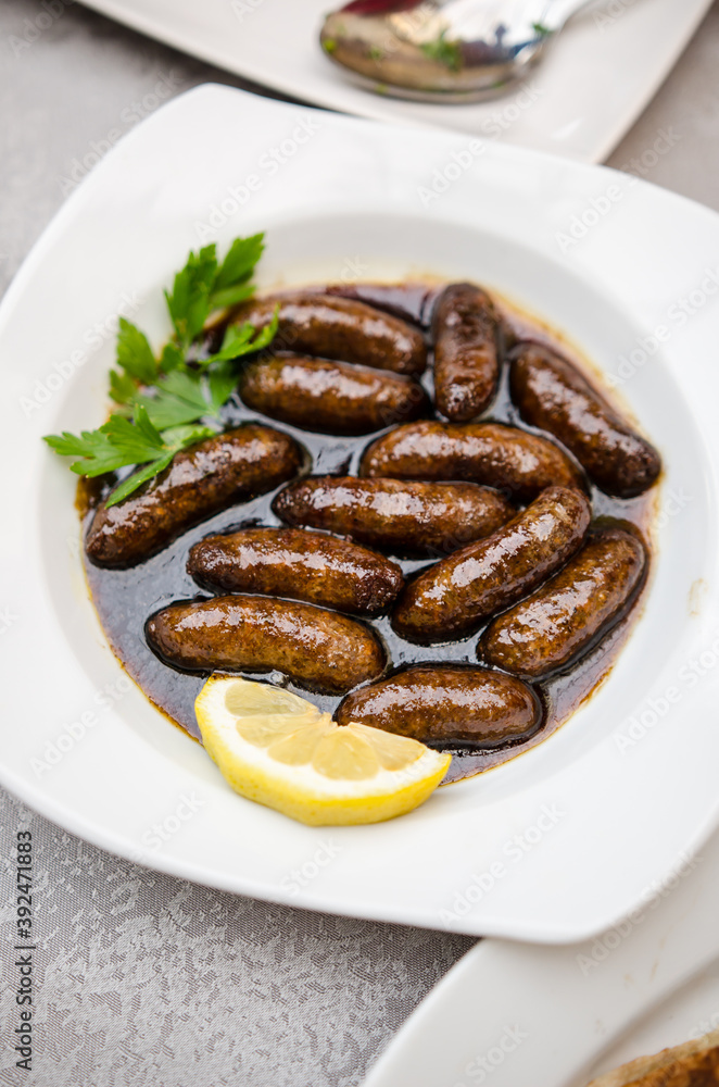Makanek (Lebanese Sausages) served in a hot pomegranate molasses with lemon and parsley Makanek (Lebanese Sausages) served in a hot pomegranate molasses with lemon and parsley