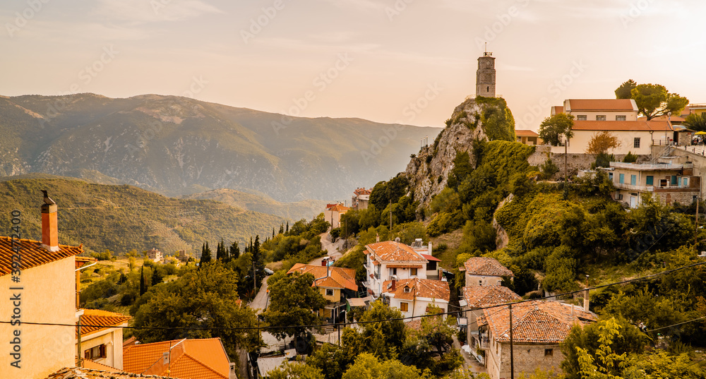 Obraz premium Panoramic sunset view of houses, mountains, and the iconic 18th-century bell tower