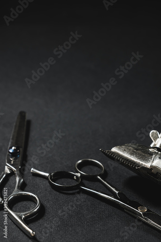 On a black surface are old barber tools. black monochrome. Barbershop background. contrast shadows. Vertical.