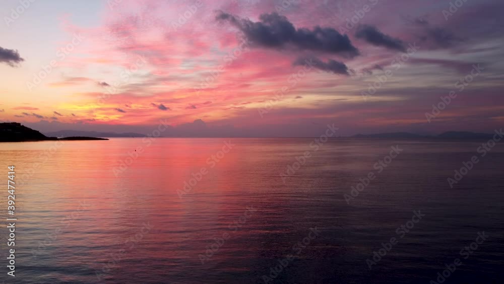 A intense sunset with red, orange and pink clouds over calm sea in the mediterranean A intense sunset with red, orange and pink clouds over calm sea in the mediterranean