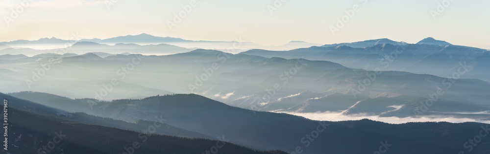 Mountain landscape with fog at sunrise with soft light.
