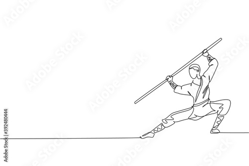 One continuous line drawing young shaolin monk man practice kung fu using long staff at temple ground. Traditional Chinese combative sport concept. Single line draw design graphic vector illustration