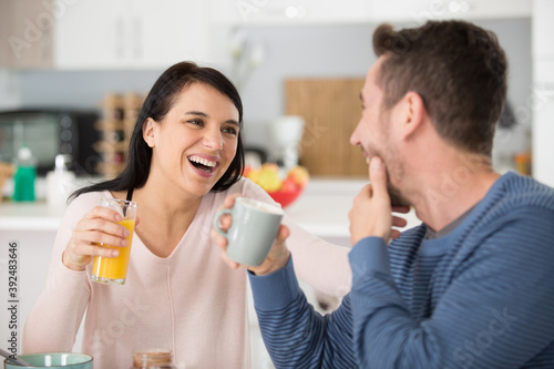 relaxed couple laughing while having breakfast