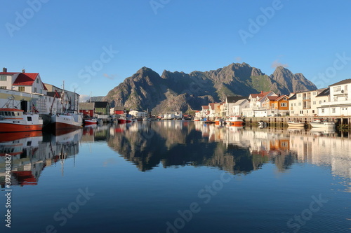Boats in Henningsvaer harbor with mountain in background 