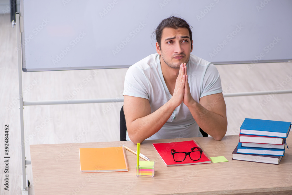 Young male teacher student sitting in the classroom Young male teacher student sitting in the classroom