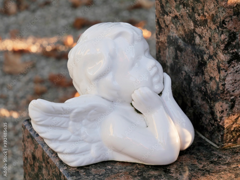 Obraz premium Weißer Engel aus Porzellan auf einem Grab