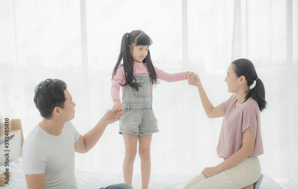 Happy asian family mother, father and daughter on bed in bedroom. Happy asian family mother, father and daughter on bed in bedroom.