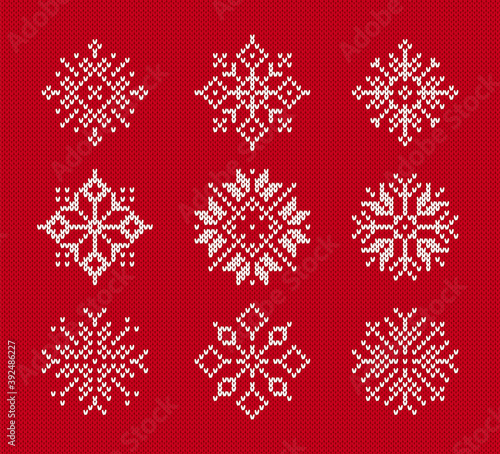 Snowflakes on knitted pattern. Vector illustration. Set of Christmas winter symbols on red seamless background. Sweater knit texture.