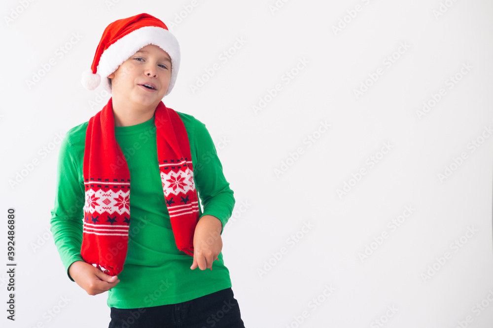 Portrait of happy boy wearing Santa Claus hat and winter scarf. Merry Christmas time. Portrait of happy boy wearing Santa Claus hat and winter scarf. Merry Christmas time.