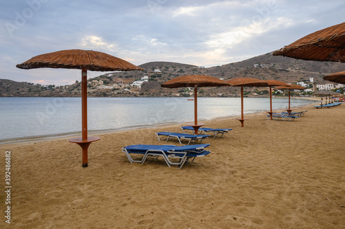 A row of umbrellas on sandy beach of Chora on Ios Island. Cyclades, Greece