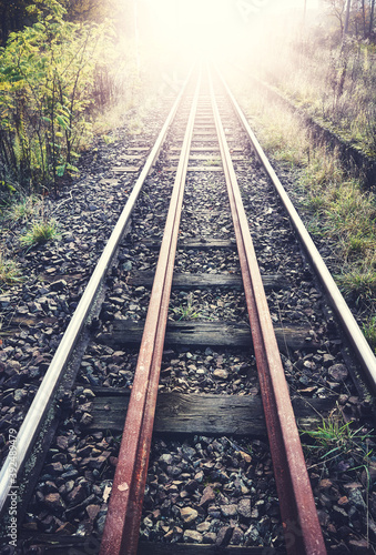 Facing light on the railroad tracks, color toned picture.