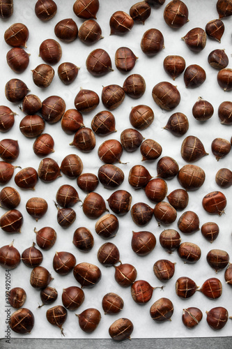 Lots of baked chestnuts on a baking sheet. View from above. Background.