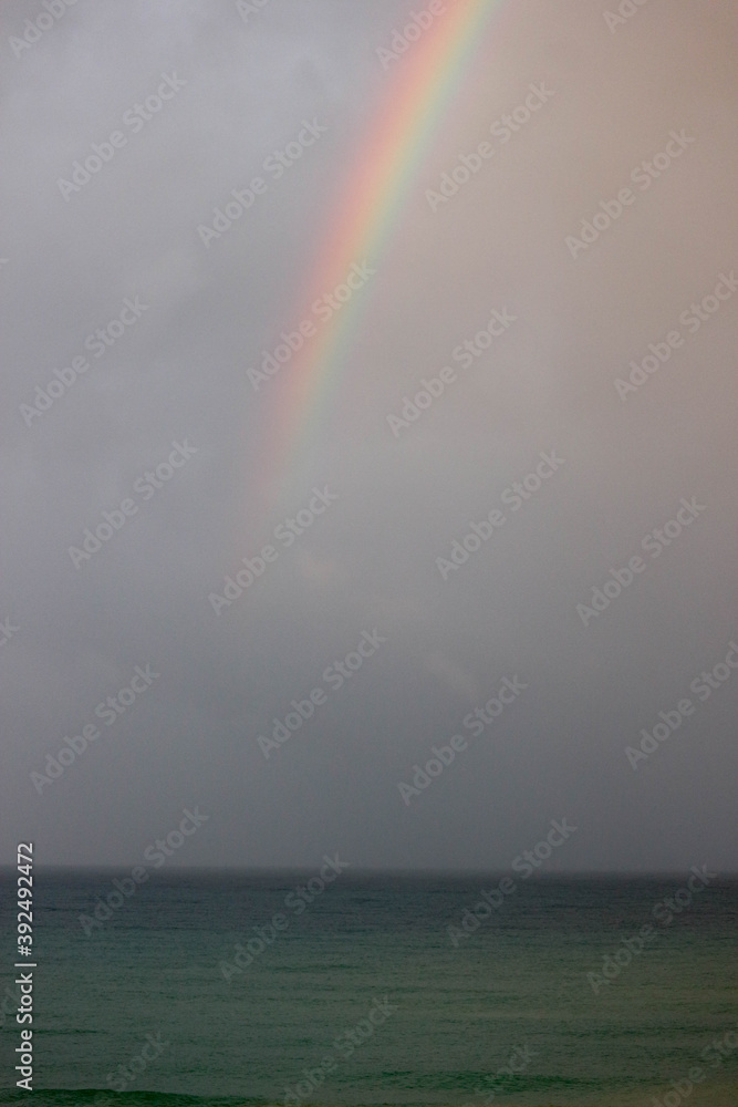 bright beautiful colorful full arc rainbow over the sea