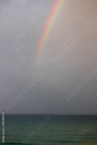 bright beautiful colorful full arc rainbow over the sea