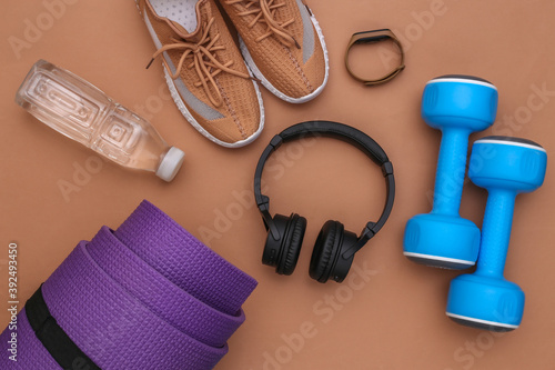 Flat lay composition sports and fitness accessories on brown background. Ready for training. Top view
