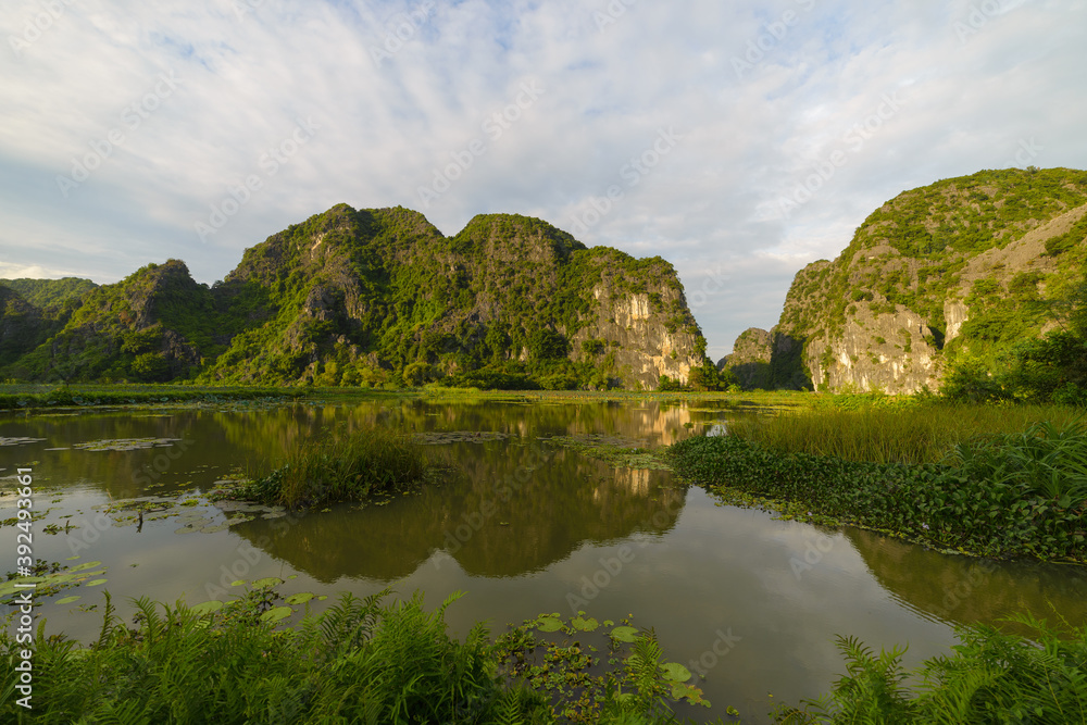 Ninh Binh region, Trang An Tam Coc valley tourist attraction, UNESCO World Heritage Site, scenic river crawling through karst mountain ranges in Vietnam, travel destination.
