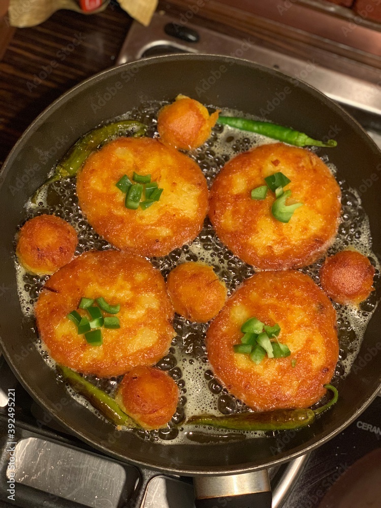 Iranian potato vegetarian cutlets with green pepper boiling in oil on the oven Iranian potato vegetarian cutlets with green pepper boiling in oil on the oven