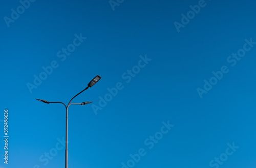 The street light pole with a blue sky background - Automatic street twin lamp against the blue sky with copy space