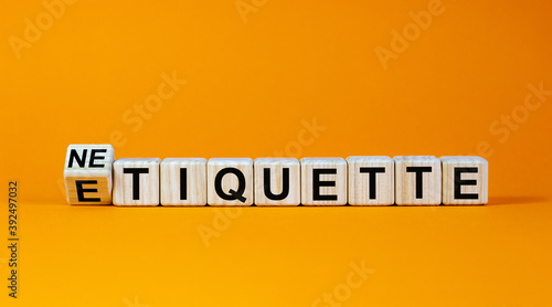 Etiquette or netiquette. Turned cube and changed the word 'etiquette' to 'netiquette'. Beautiful orange background. Business concept. Copy space.