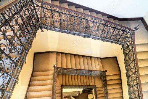 Photography Top view of a stone staircase with cast iron railings in an old house in the his