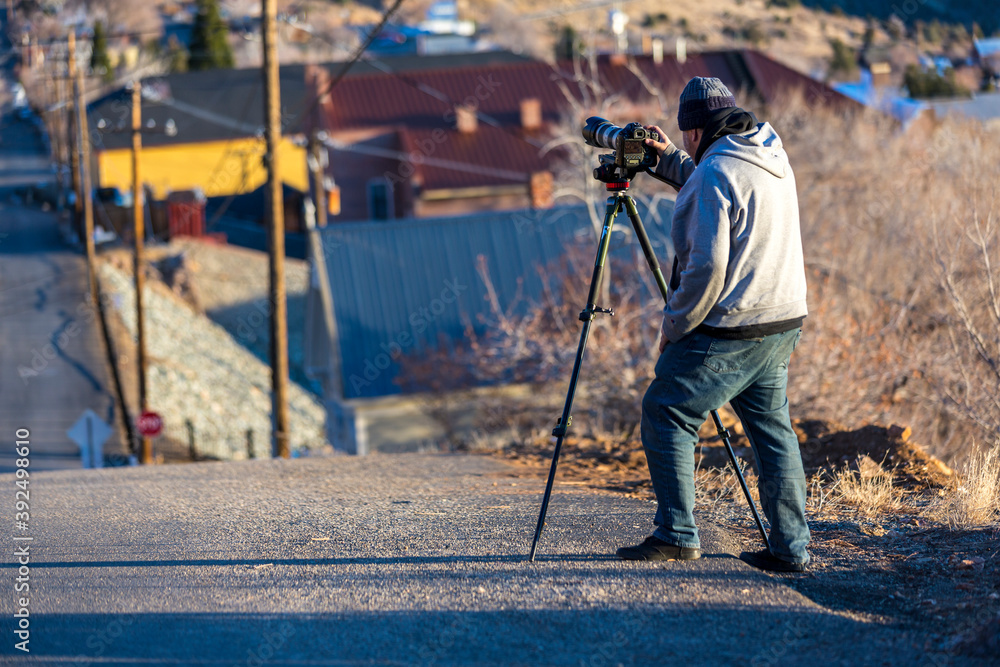 Photographer warmly dressed on a cold day taking pics down a steep street Photographer warmly dressed on a cold day taking pics down a steep street