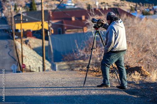 Photographer warmly dressed on a cold day taking pics down a steep street
