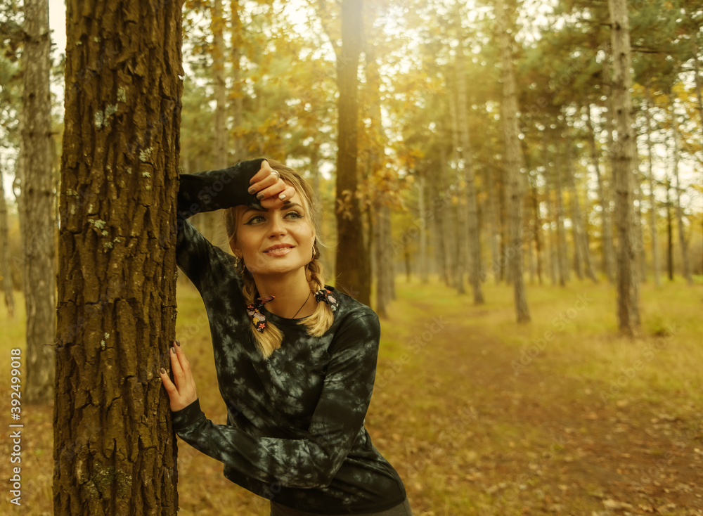 Young tired fit woman in sportswear leaned on a tree after an intense jog in the autumn forest. Healthy lifestyle concept. Outdoor workout Young tired fit woman in sportswear leaned on a tree after an intense jog in the autumn forest. Healthy lifestyle concept. Outdoor workout