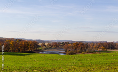 Czech autumn landscape. Dry pond Dehtar with meadow  trees and distant hill at day time