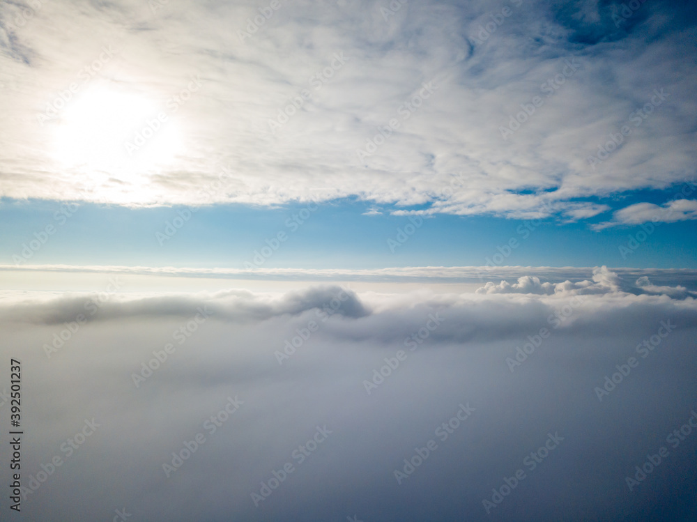 Aerial view. Flying over white clouds during the day in sunny weather.