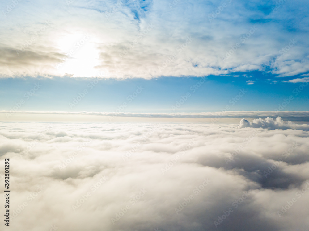 Aerial view. Flying over white clouds during the day in sunny weather.