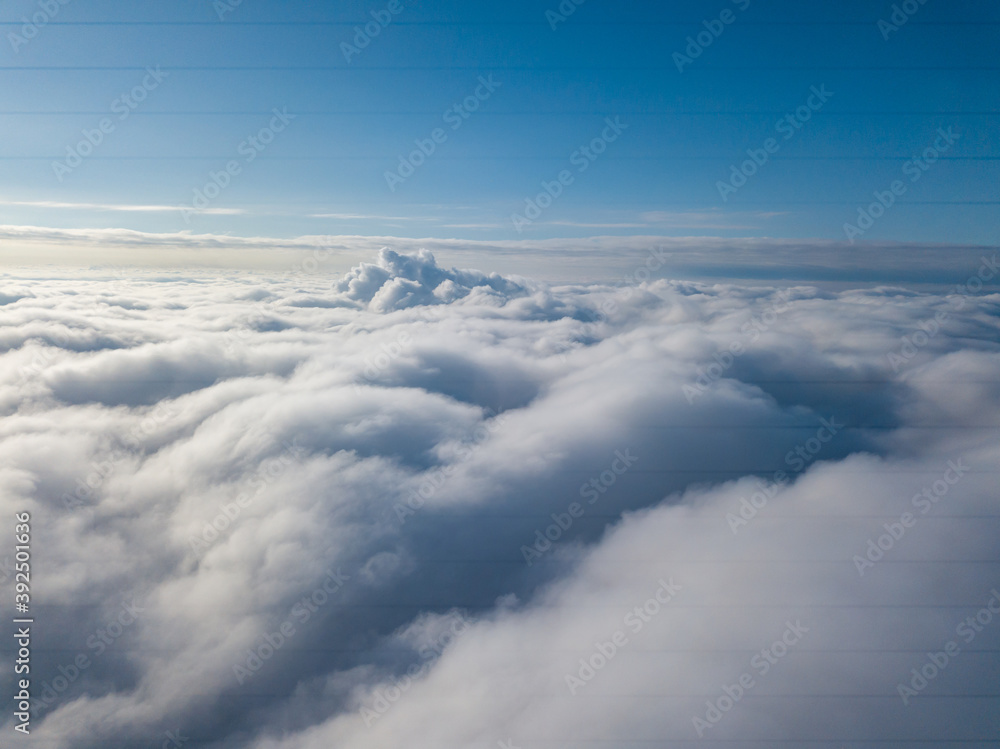 Fototapeta premium Aerial view. Flying over white clouds during the day in sunny weather.