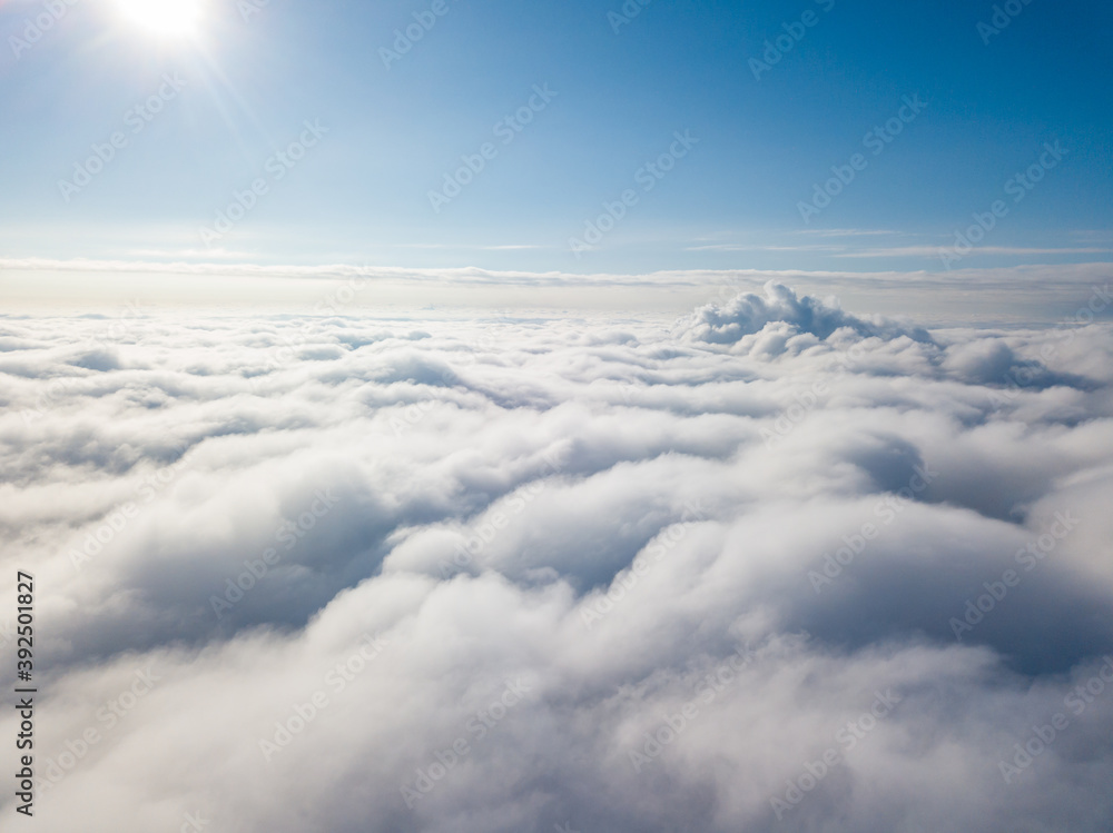 Naklejka premium Aerial view. Flying over white clouds during the day in sunny weather.