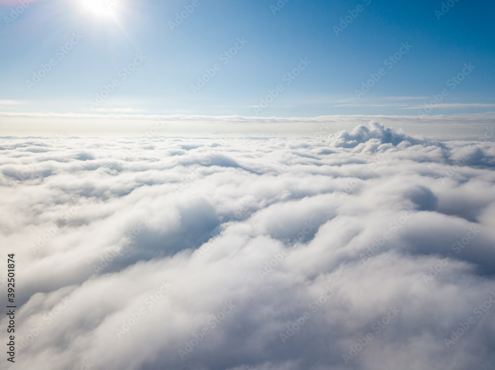 Aerial view. Flying over white clouds during the day in sunny weather.