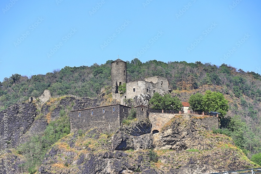 a dilapidated castle on top of a high cliff above the river