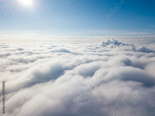 Aerial view. Flying over white clouds during the day in sunny weather.