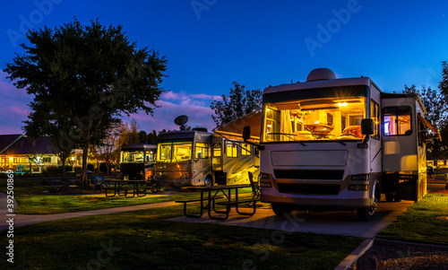 Rving at a resort in the evening lighted sky with class A rigs interior lights on