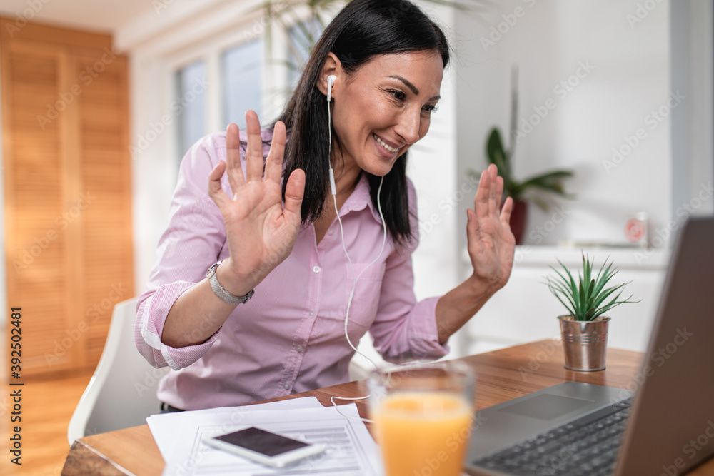 Attractive and happy middle age female freelancer is working from home during Coronavirus or Covid-19 lockdown or quarantine. Social distancing and freelancing job concept. Attractive and happy middle age female freelancer is working from home during Coronavirus or Covid-19 lockdown or quarantine. Social distancing and freelancing job concept.