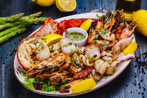 Seafood platter.Grilled lobster, shrimps, scallops, langoustines, octopus, squid on white plate.