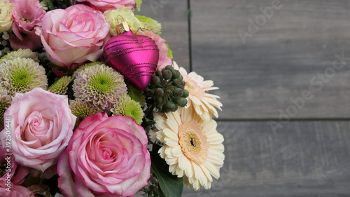 beautiful fresh bouquet with pink roses and a shiny love heart bauble