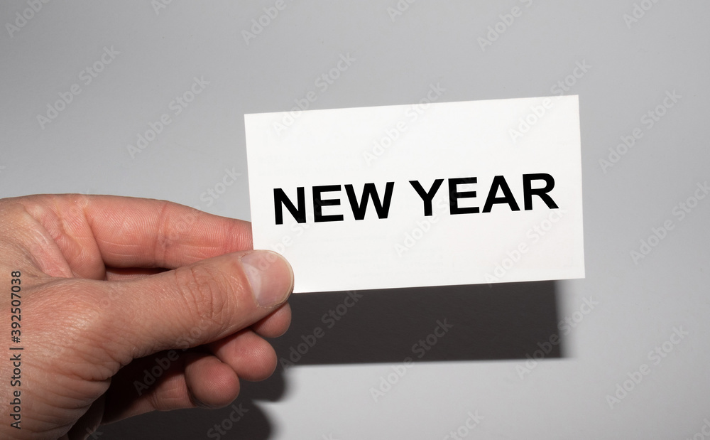 Message on the card NEW YEAR, in hands of businessman. Message on the card NEW YEAR, in hands of businessman.