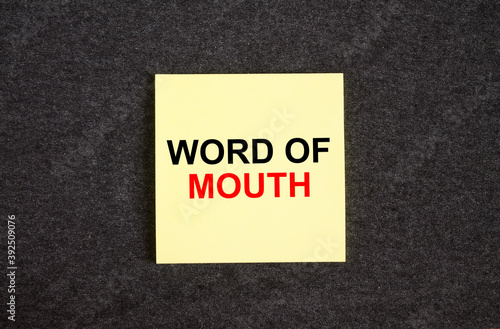 Yellow sticker on the dark gray texture background with text Word Of Mouth