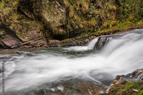 Long exposure of a waterfall on the Hoar Oak Water river at Watersmmet in Exmoor National Park in autumn photo