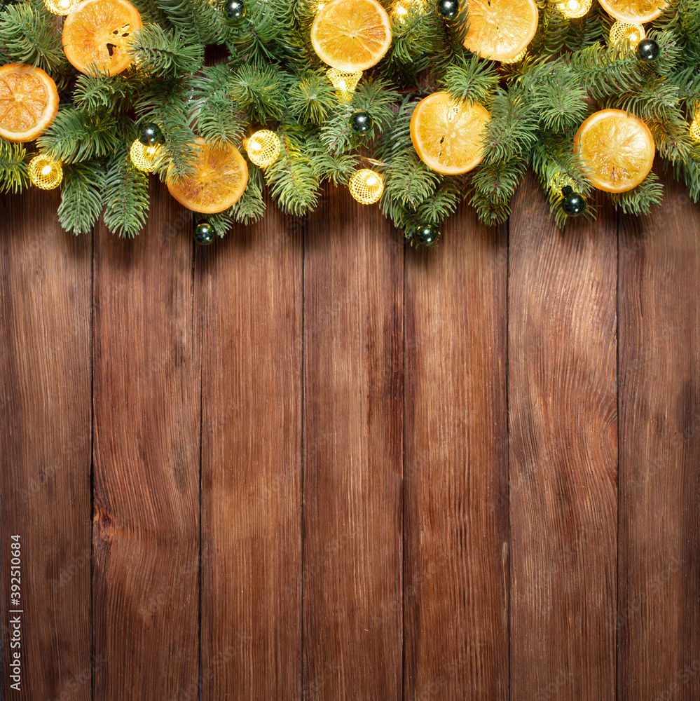 fir tree with festive lights and Christmas decoration on wooden background with copy space