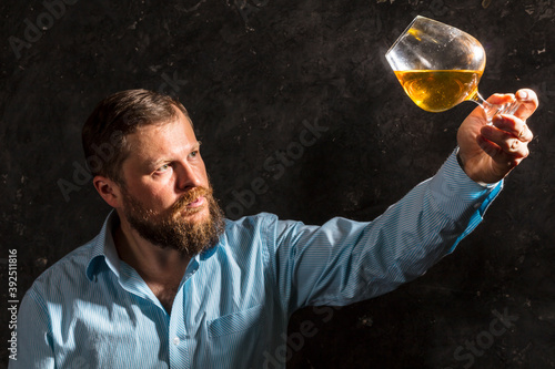 Solid bearded man in shirt with glass of whisky